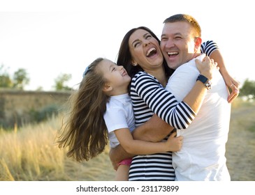 Young happy family frolics outdoors in summer - Shutterstock ID 231173899