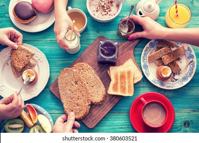 Молодая счастливая семья за завтраком