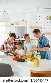 Young Happy Family Making Sandwich At Home. Mom And Dad Preparing Breakfast With Sons.