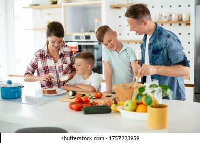 Young Happy Family Making Sandwich At Home. Mom And Dad Preparing Breakfast With Sons.