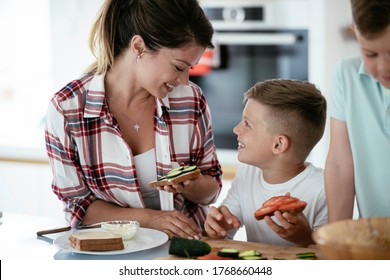 Young Happy Family Making Sandwich At Home. Mom Preparing Breakfast With Sons.