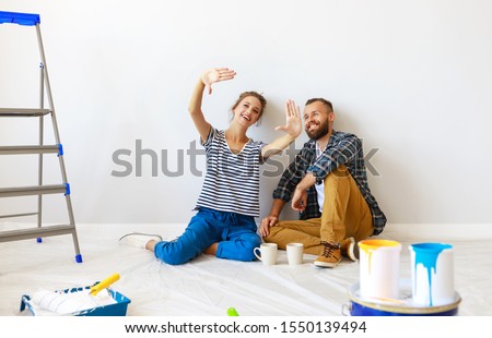 young happy family married couple dreams of renovating  house and planning a design project
