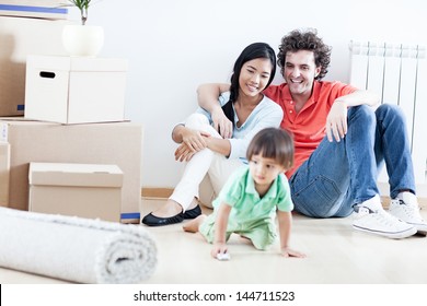 Young happy family relaxing after they have moved into their new home. - Powered by Shutterstock