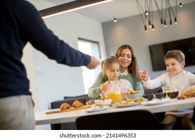 Young happy family talking while having breakfast at dining table at apartment - Powered by Shutterstock