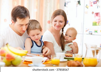 Young Happy Family With Two Kids Having Breakfast Together