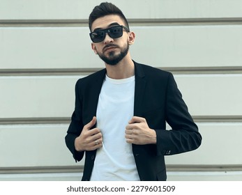 A young happy fashionable man posing outside. High quality photo - Shutterstock ID 2279601509