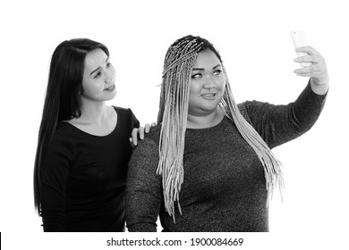 Young Happy Fat Asian Woman And Asian Transgender Woman Smiling While Taking Selfie Picture With Mobile Phone