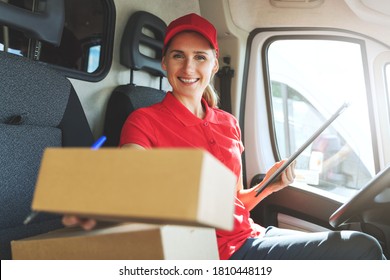 young happy female delivery service worker sitting in van and delivering a box - Powered by Shutterstock