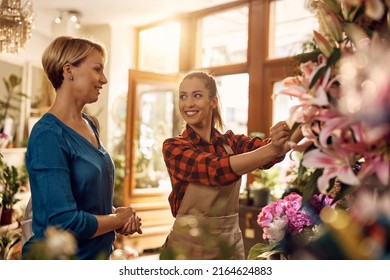 Young Happy Flower Shop Owner Assisting  Her Customer In Choosing Flowers At Flower Shop.