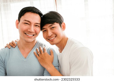 Young happy gay couple in love, proposing and marriage surprise show a wedding ring in the living room at home. Gay men proposal engagement concept. Surprised partner is very happy. Relationship goal. - Powered by Shutterstock