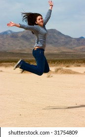 A Young Happy Girl Jumping In The Nevada Desert ( Dry Lake Bed)