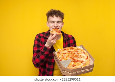 young happy guy eating pizza on yellow background, hungry student enjoying fast food - Powered by Shutterstock