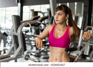 Young Happy Healthy Attractive Muscular Asian Woman Showing Six Pack Abs Standing In The Gym, Fitness And Sport Concept.