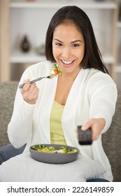 Young Happy Healthy Woman Eating Salad While Watching Tv