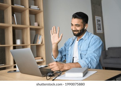 Young Happy Indian Arab Eastern Man Talking On Video Conference Call Greeting Waving Hand Using Laptop At Modern Home Office. Remote Distant Online Communication Technologies Concept.