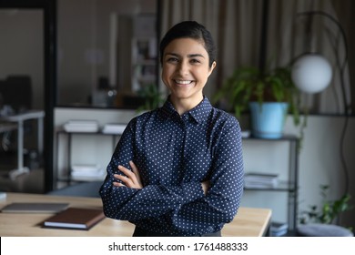 Young Happy Indian Ethnicity Corporate Staff Member, Successful Promoted Employee Portrait. Businesswoman Standing With Arms Crossed Feels Confident Smiling Looking At Camera, Photo Shooting In Office