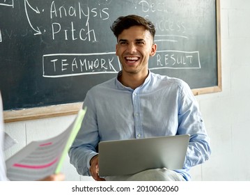 Young Happy Indian Latin Man Student With Laptop Laughing During College Seminar Class. Smiling Llatin Hispanic Businessman Enjoying Creative Brainstorm In Modern Contemporary Office At Meeting.