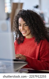 Young happy latin business woman office worker, company employee or student using laptop, typing on computer sitting at desk in office watching online webinar, elearning course looking at pc. Vertical - Shutterstock ID 2257912255