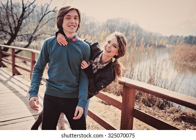 Young Happy Loving Couple Having Fun On The Walk In Early Spring On Riverside, Casual Lifestyle Series