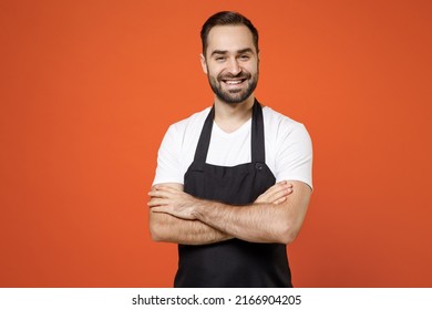 Young happy man barista bartender barman employee in black apron white t-shirt work in coffee shop hold hand crossed folded isolated on orange background studio portrait Small business startup concept - Powered by Shutterstock