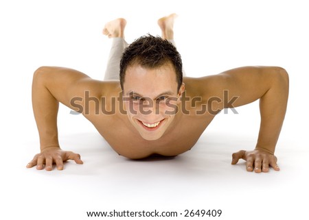 Young happy man doing push up exercise. White background in studio.