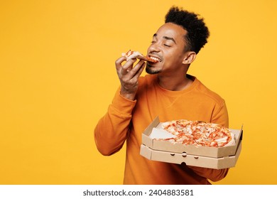 Young happy man he wears orange sweatshirt casual clothes holding italian pizza in cardboard flatbox isolated on plain yellow background. Proper nutrition healthy fast food unhealthy choice concept - Powered by Shutterstock