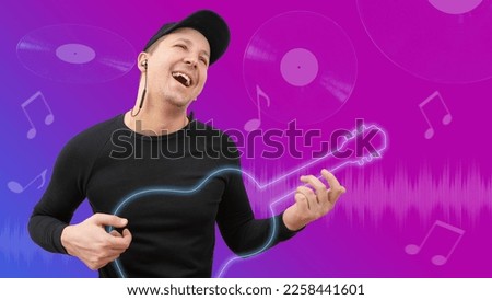 Young happy man in headphones has fun playing an imaginary guitar and listening to music.