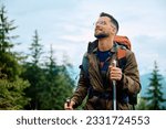 Young happy man hiking in the mountains. Copy space.