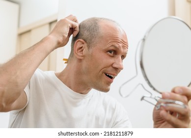 Young Happy Man Looking At Mirror After Self Haircut At Home