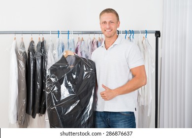 Young Happy Man Standing With Coat In Dry Cleaning Store