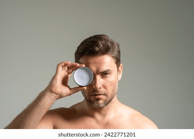 Young happy manful guy applying face cream. Close up shot of attractive man with healthy skin, applies cream for anti wrinkle or anti aging, cares of body. Beauty portrait. Body positive. Skin - Powered by Shutterstock