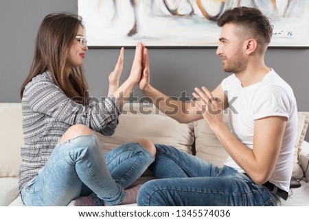 Young and happy married couple sitting on sofa in apartment