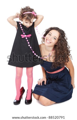 Young happy mother and her funny little girl in mummy's shoes over white