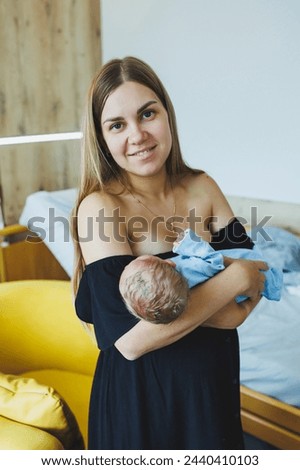 Similar – Mother giving bottle to her newborn