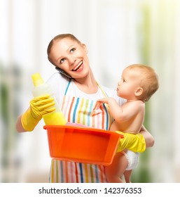 Young Happy Mother Is A Housewife With A Baby Does Homework And Talking On The Phone At Home