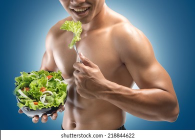 Young Happy Muscular Man Eating A Salad