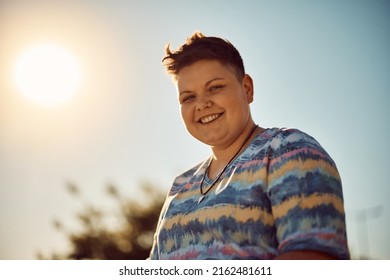 Young happy non-binary woman against the sky looking at camera.  - Shutterstock ID 2162481611