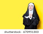Young happy nun on yellow background
