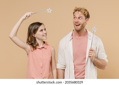 Young happy parent man with child teen girl wear casual clothes Daddy kid daughter hold princess magic wand feia stick kidding isolated on beige background studio. Father's Day birthday family concept - Powered by Shutterstock