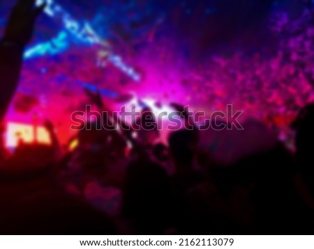 Young happy people are dancing in club. Nightlife and disco concept. Blurred background concept