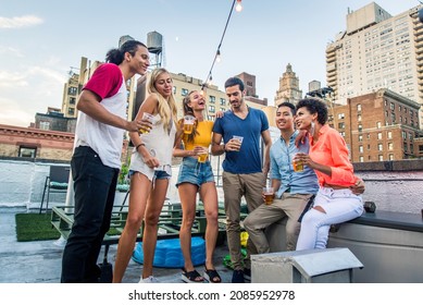 Young happy people having a barbecue dinner on a rooftop in New York - Group of friends having party and having fun