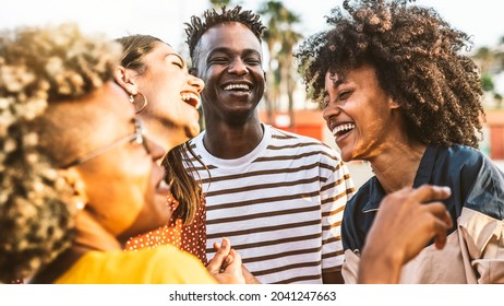 Young happy people laughing together - Multiracial friends group having fun on city street - Diverse culture students portrait celebrating outside - Friendship, community, youth, university concept	 - Shutterstock ID 2041247663