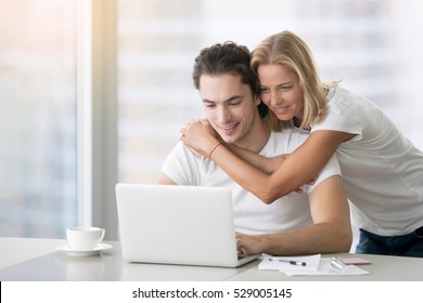 Young Happy People Looking At Laptop, Building Family Financial Plan, Meal Planning For Healthy Style, Wedding Ideas, Ordering Gifts, Free Online Courses To Get Diploma. Man Working In Home Office