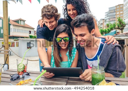 Similar – Young happy people looking tablet over table