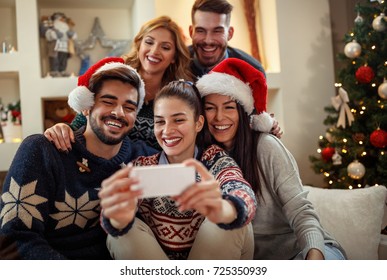 Young happy people making Christmas selfie