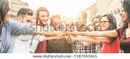 Young happy people stacking hands outdoor - Diverse culture students celebrating together - Youth lifestyle, university, relationship, human resorces, work and friendship concept - Focus on hands