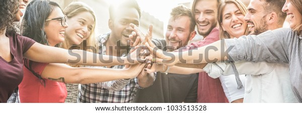 Young happy people stacking hands outdoor - Diverse\
culture students celebrating together - Youth lifestyle,\
university, relationship, human resorces, work and friendship\
concept - Focus on hands