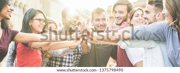 Young happy people stacking hands outdoor - Diverse\
culture students celebrating together - Youth lifestyle,\
university, relationship, human resorces, work and friendship\
concept - Focus on hands