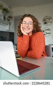Young happy pretty business woman student sitting at desk at home office with laptop computer looking at camera advertising online learning, remote work, business webinars. Vertical portrait. - Shutterstock ID 2228645281