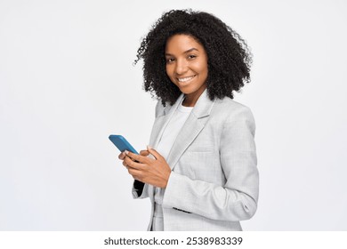 Young happy professional African American business woman wearing suit holding cell phone, looking at camera with cellphone, using mobile apps on smartphone standing isolated on white, portrait.